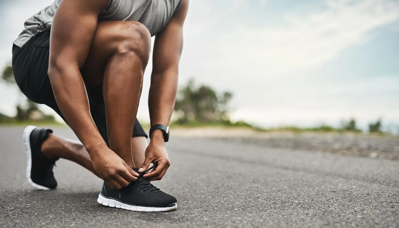 hands, shoelace and man in street, practice for health benefits and training. outdoor, athlete and person with sneakers, exercise and fitness for wellness, start day and feet with morning routine