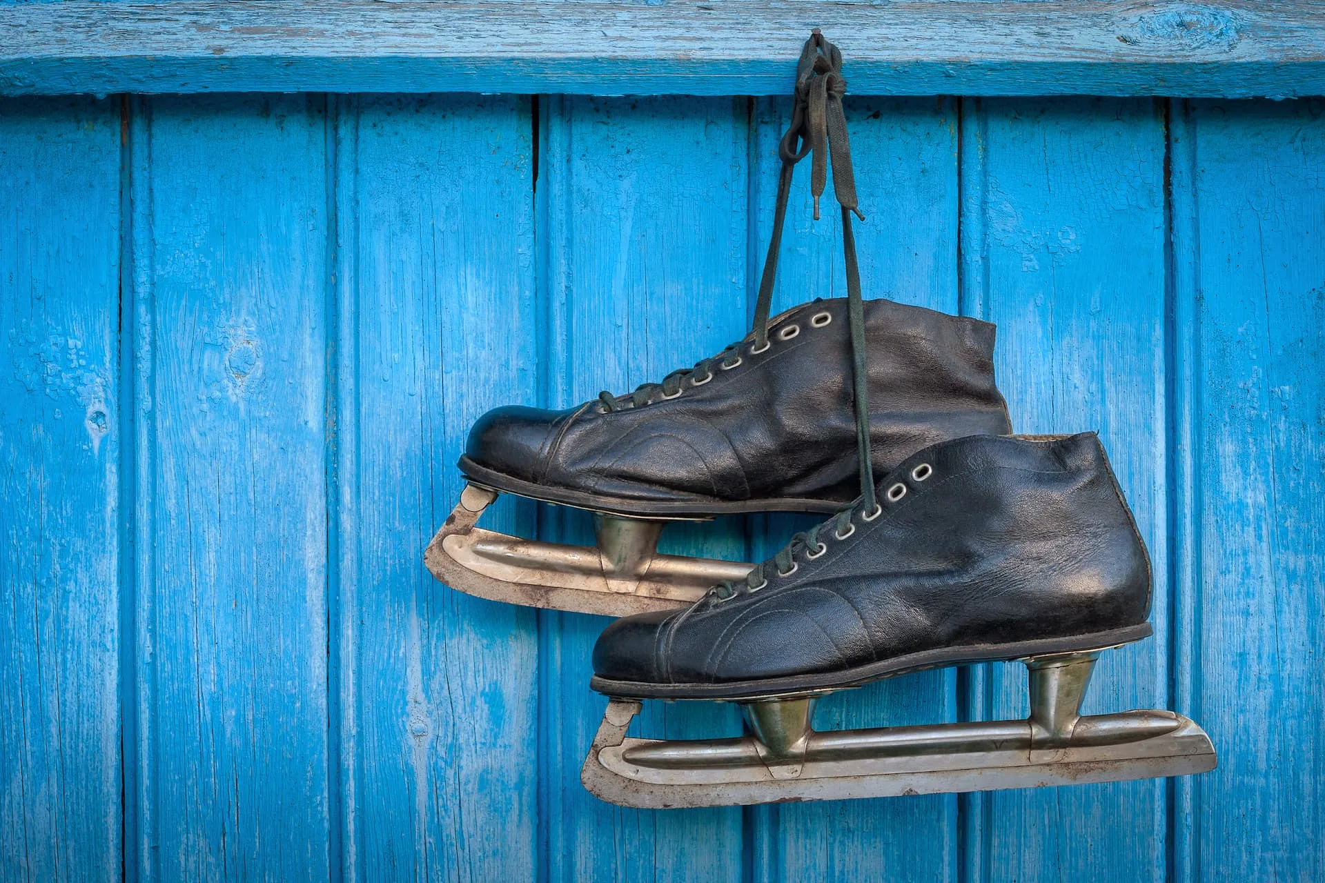 vintage schaatsen aan blauwe houten muur